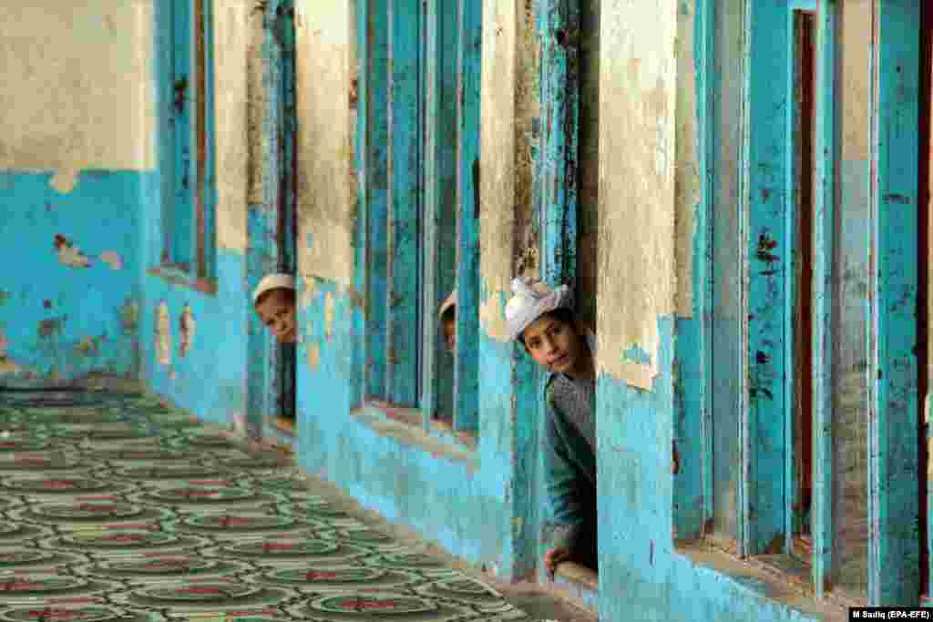 Afghan boys peek out inside a madrasah during the Muslim holy month of Ramadan amid the coronavirus pandemic in Kandahar. (epa-EFE/M. Sadiq)