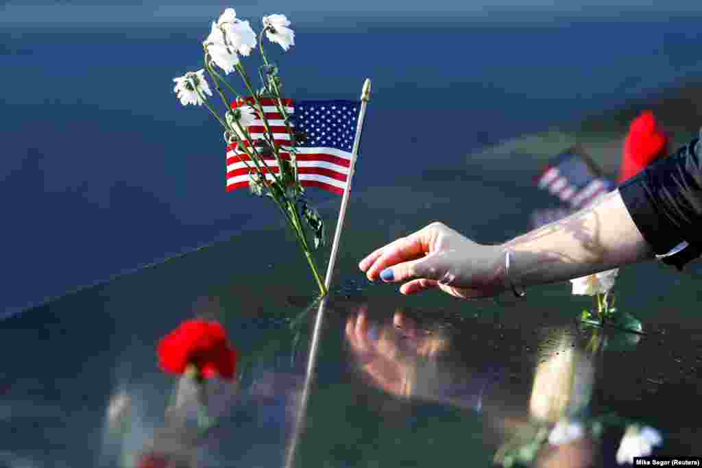 Një grua vendos lule dhe një flamur amerikan në memoralin për viktimat e 11 shtatorit në Nju Jork, teksa Shtetet e Bashkuara shënojnë 20-vjetorin e sulmeve terroriste.&nbsp;