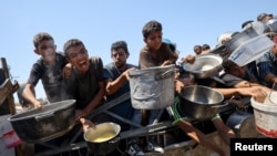 Palestinezët duke pritur për pak ushqim në një kuzhinë bamirëse në qytetin e Gazës. Fotografi e 24 korrikut.
