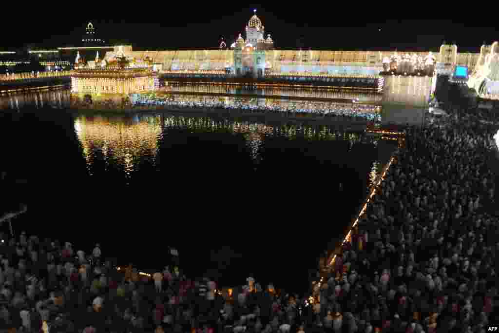 OCTOBER 9, 2012 -- Indian Sikh devotees pay their respects at the illuminated Sikh Shrine Golden Temple for the anniversary of the Sikh guru Ramdass in Amritsar. Ramdass was born in Lahore, Pakistan, in 1574 and is known as the Chauthi Patshahi, or the fourth guru, as well as the guru who established the city of Amritsar. (AFP/Narinder Nanu)