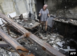 Жінка у зруйнованій внаслідок бойових дій будівлі, Слов'янськ, серпень 2014 року