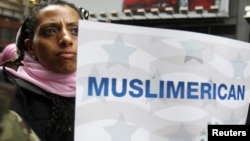 Америкалық азаматша "Мен де мұсылманмын" деген қолдау плакатын көтеріп тұр. Нью Йорк, 6 наурыз 2011 жыл. Көрнекі сурет