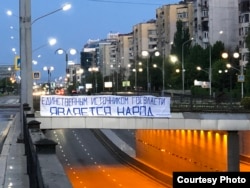 Баннер с надписью «Единственным источником госвласти является народ» на мосту в Алматы.