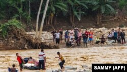 Indonezija - Seljani koriste napuhane cijevi guma za isporuku zaliha preko rijeke u selu Banjar Irigasi u Lebaku, provincija Banten - 2. januara 2020.