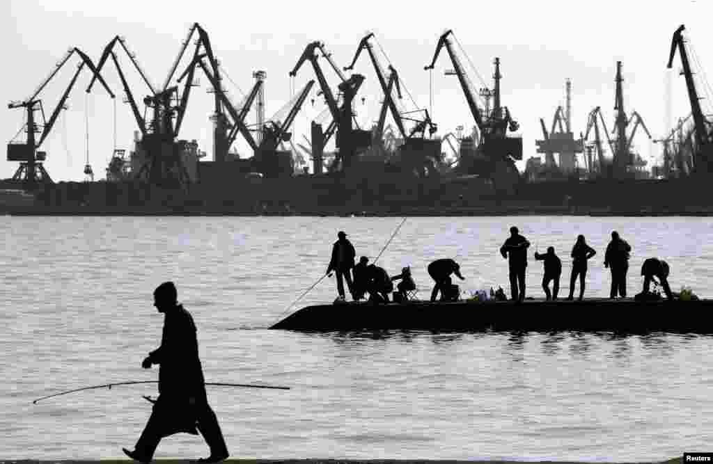 People fish on a pier at the port of Mariupol, located on the north of the Sea of Azov in eastern Ukraine. (Reuters/Yannis Behrakis)