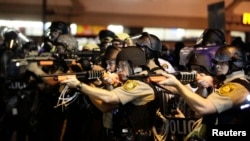 Police officers point their weapons at demonstrators protesting the shooting death of Michael Brown in Ferguson, Missouri, on August 18.