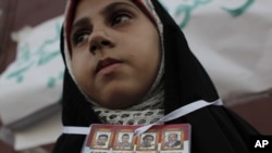 An Egyptian protester with pictures of Egyptians killed during the revolution takes part in a demonstration in Suez on July 8.