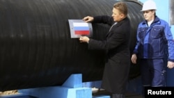 "Газпром" басшысы Алексей Миллер газ құбырына Ресей туын жапсырып тұр. (Көрнекі сурет)
