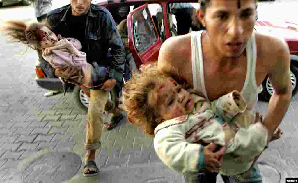 Palestinians carry two wounded Palestinian babies after an Israeli artillery shell hit their house in the northern Gaza strip April 10, 2006. An Israeli artillery shell killed a young Palestinian girl and injured 12 others, including five children, when it hit a house in the northern Gaza Strip on Monday, Palestinian security sources and witnesses said. REUTERS/Mohammed Salem 