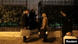 Investigators enter a residence block where Russian diplomat Andrei Malanin was found dead in his apartment in Athens, Greece, on January 9.