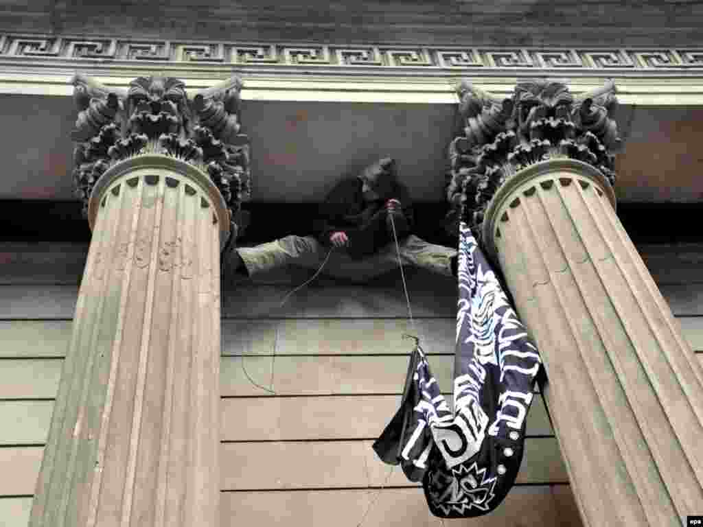 Velika Britanija - Protest - Ovaj je protestant u Londonu poželio da na zgradu Engleske banke postavi protestnu parolu.