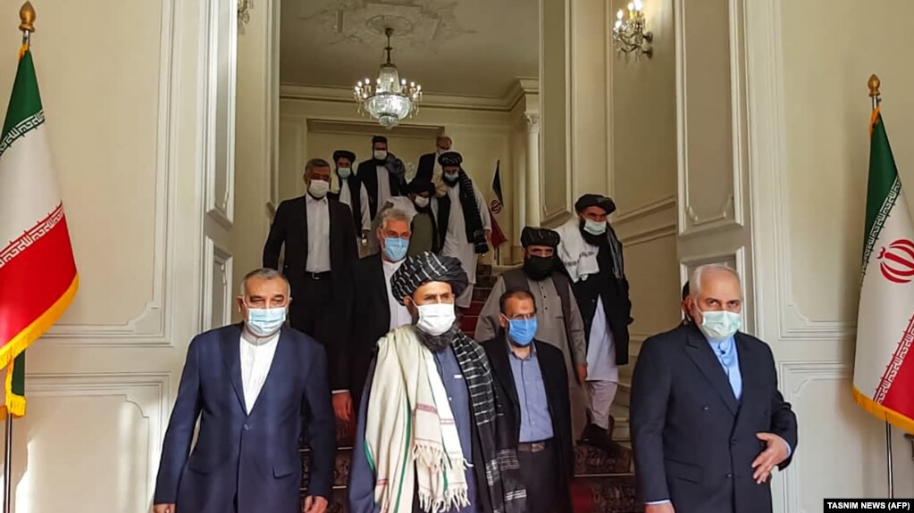 Iranian Foreign Minister Mohammad Javad Zarif (right) meets with Taliban political leader Mullah Abdul Ghani Baradar (center) in Tehran in January. Tehran may not be willing to see its onetime foe take power across the border.