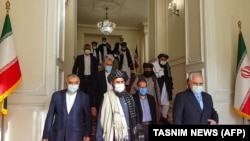Иран сыртқы істер министрі Мохаммад Жавад Зариф (оң жақта) пен "Талибан" қозғалысының саяси жетекшісі Абдул Ғани Барадар (ортада) биыл қаңтарда Тегеранда кездескен.