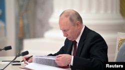 Russia - President Vladimir Putin signs documents, including a decree recognizing two Russian-backed breakaway regions in eastern Ukraine as independent entities, during a ceremony in Moscow, February 21, 2022.