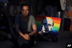 A poster depicting Russian President Vladimir Putin on a rainbow flag is seen during a rally outside Bulgaria's parliament in Sofia on August 8.