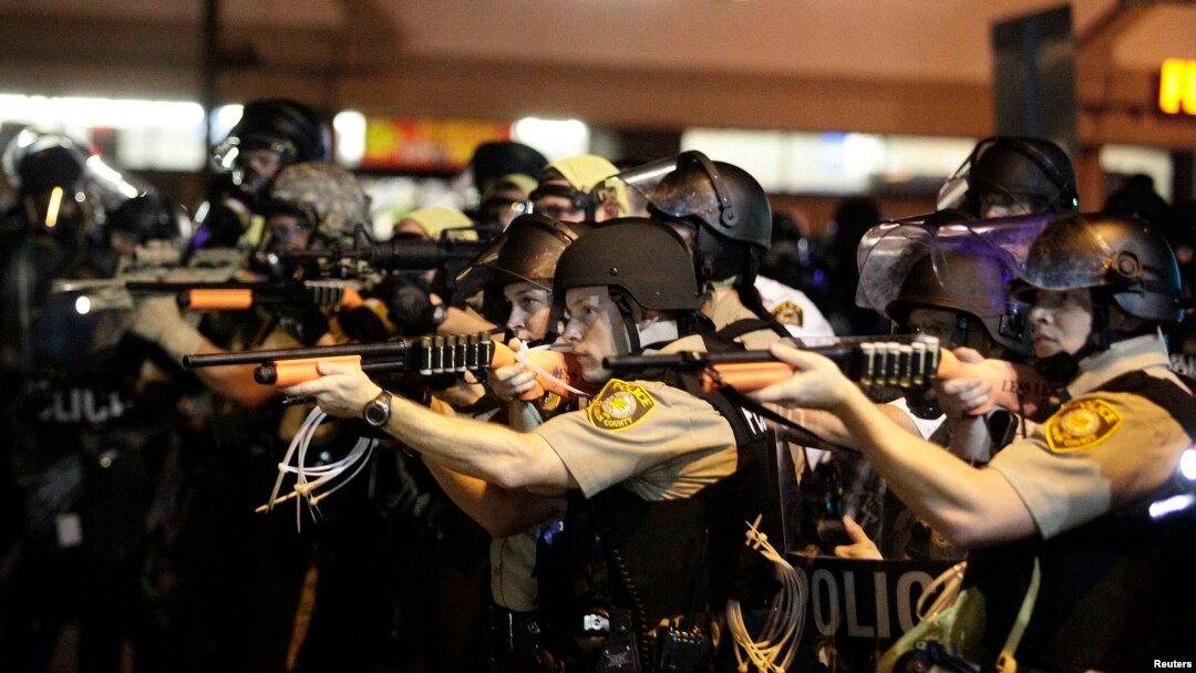Police officers point their weapons at demonstrators protesting the shooting death of Michael Brown in Ferguson, Missouri, on August 18.