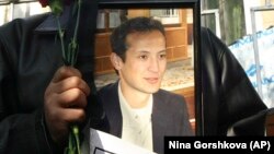 Protestçi Alişer saipowyň portretini göterip dur. Arhiw suraty