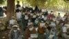 Afghans wait to receive cash distributed through an aid program in the Pachiragam Khogyani district of Nangarhar Province. (file photo)