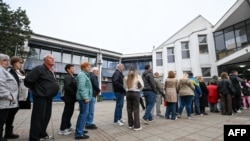 Alegători din orașul Novi Sad, în nordul Serbiei, stau la coadă pentru a vota în alegerile parlamentare anticipate, pe 25 octombrie 2026.