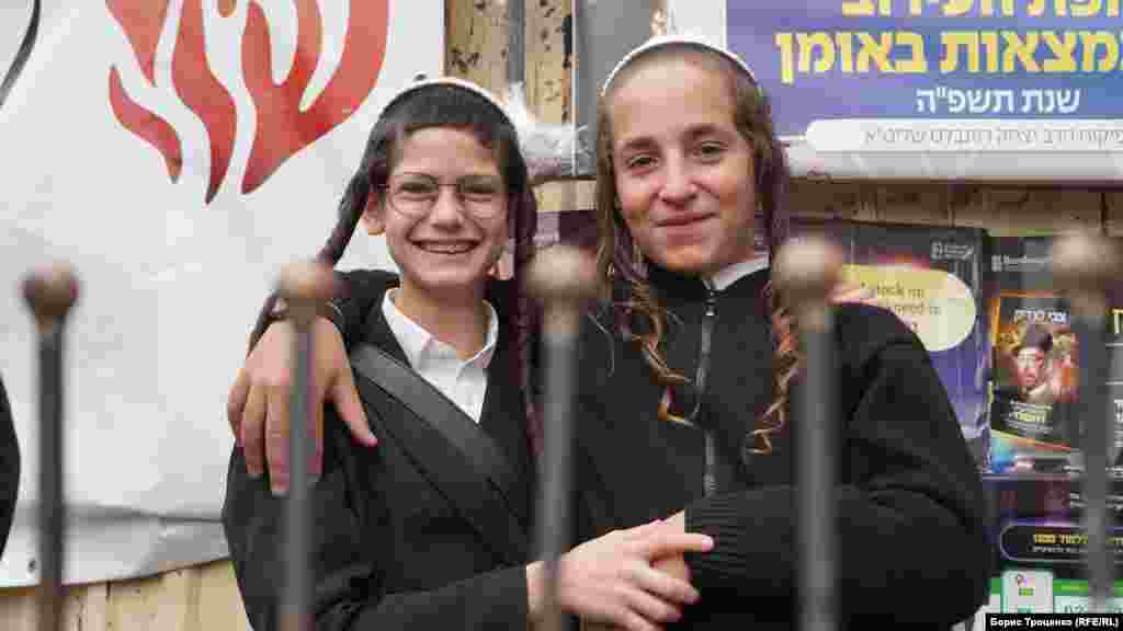 Hasidic boys in traditional peis smile as they pose for a photo. &nbsp;