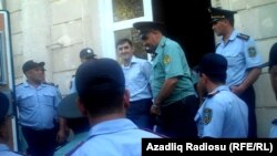 Әзербайжан құқық қызметкерлері «Мусават» партиясы жастар ұйымының төрағасы Турал Аббаслыны (ортада) сот залынан алып шығып келеді. Баку, 12 тамыз 2011 ж.