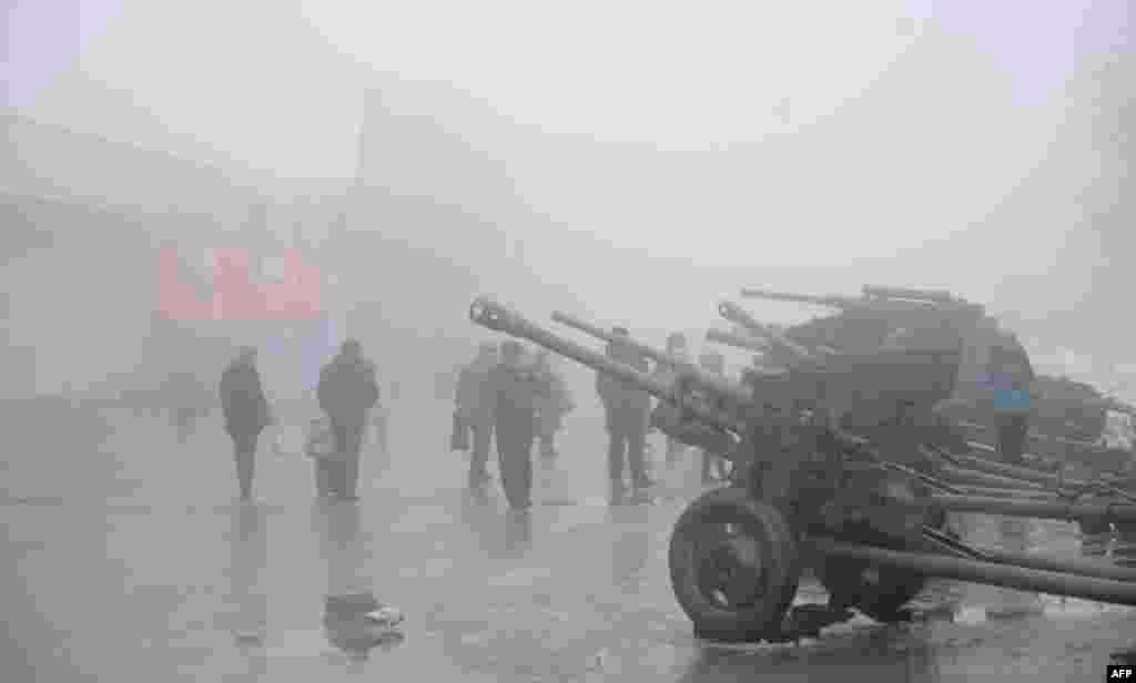 On February 3, residents of Volgograd (formerly Stalingrad) walk past guns displayed at the Stalingrad Battle memorial a day after the 70th anniversary of the end of the brutal engagement that changed the course of World War II. (AFP/Mikhail Mordasov)