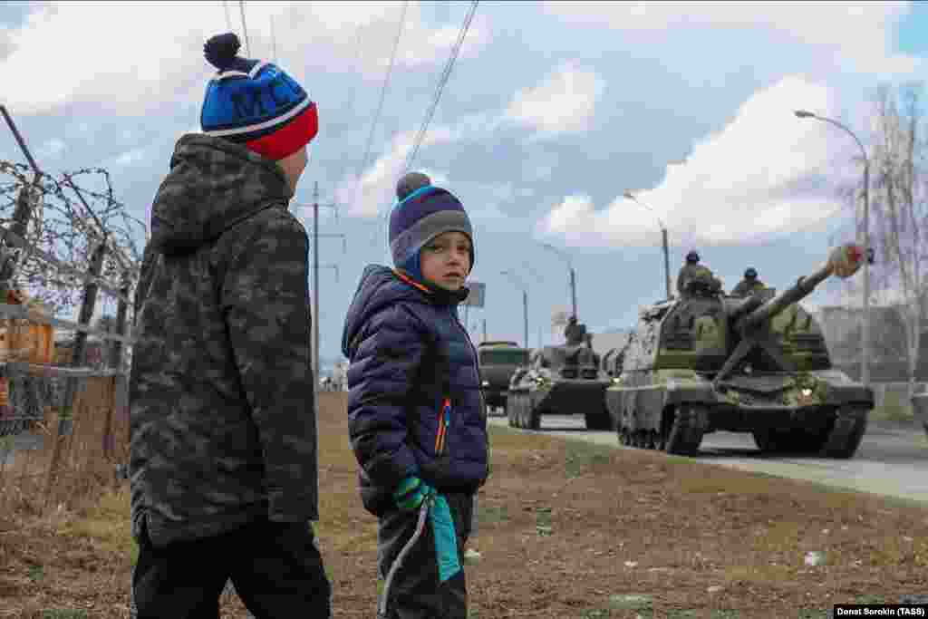 Boys watch self-propelled howitzers passing by during a rehearsal of a military parade in Yekaterinburg on April 14.