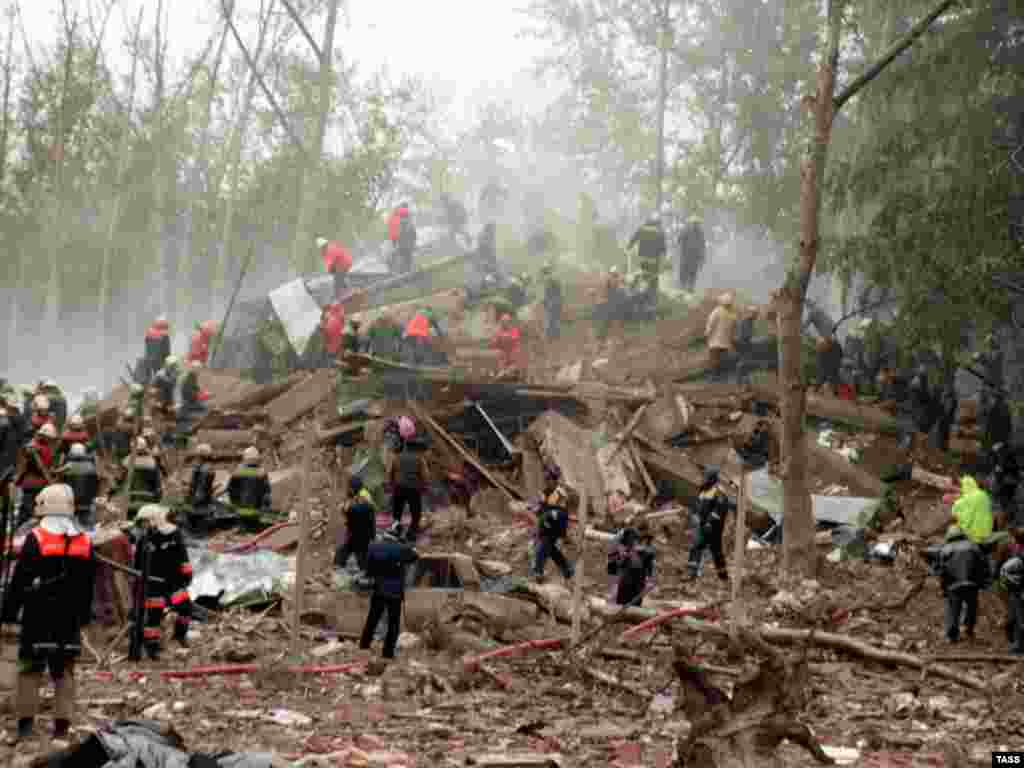 Rescuers and firefighters search the rubble of a Moscow apartment block after a bombing on September 13, 1999.