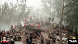 Rescuers and firefighters search the rubble left of an apartment block following a blast in Moscow in September 1999.