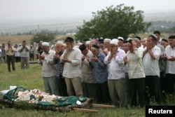 The funeral of Natalya Estemirova at a cemetery in Koshkeldy, 70 kilometers east of Grozny, on July 16, 2009.