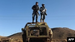 Ауған полицейлері совет әскерінен қалған көліктің қаңқасына шығып, төңіректі шолып тұр. Ауғанстан, 13 желтоқсан 2012 жыл.
