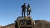 FILE: Two Afghan policemen keep watch atop the remains of a Soviet-era armored personnel carrier at Islam Qala border crossing with Iran in the western province of Iran.