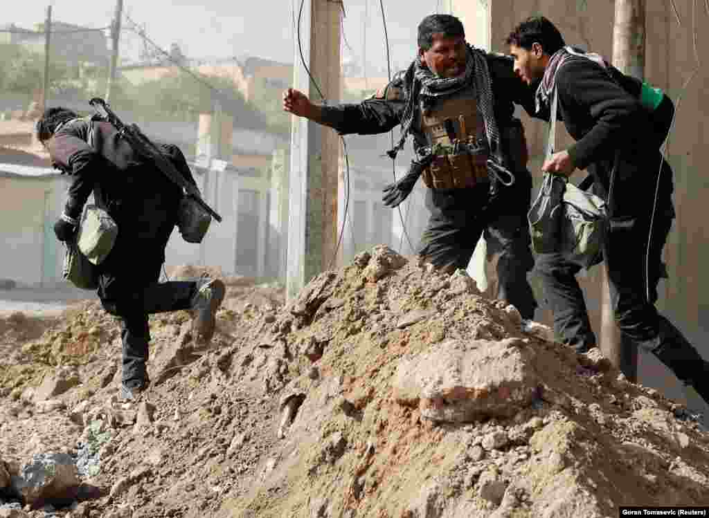 Iraqi special forces soldiers sprint across a street during clashes in Mosul on February 28. An estimated 3,000-5,000 Islamic State fighters are still holed up in the city.&nbsp;