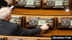 Депутат Верховной Рады нажимает на кнопку голосования.