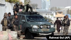 Afghan security personnel inspect the site of suicide attack near the election commission office in Kabul on October 29.