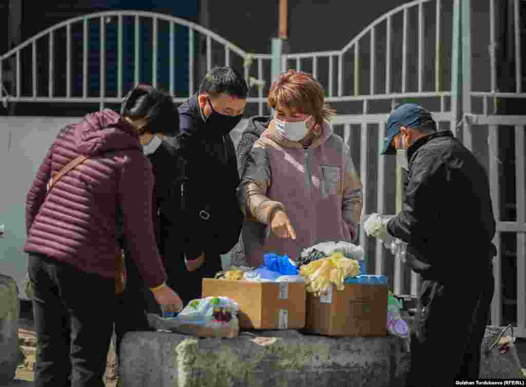 Ош базарынын жанында коргонуучу каражаттарды сатып жаткандар.