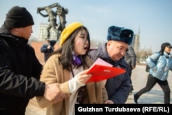 Police officers detain a protester during an International Women's Day demonstration on March 8 in Bishkek, Kyrgyzstan. As many as 70 people were detained, including journalists and human rights activists, according to RFE/RL's Kyrgyz Service. (Gulzhan Turdubaeva, RFE/RL)