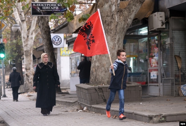 Një djalë mban në duar flamurin kombëtar shqiptar. Shkup, 28 nëntor, 2014