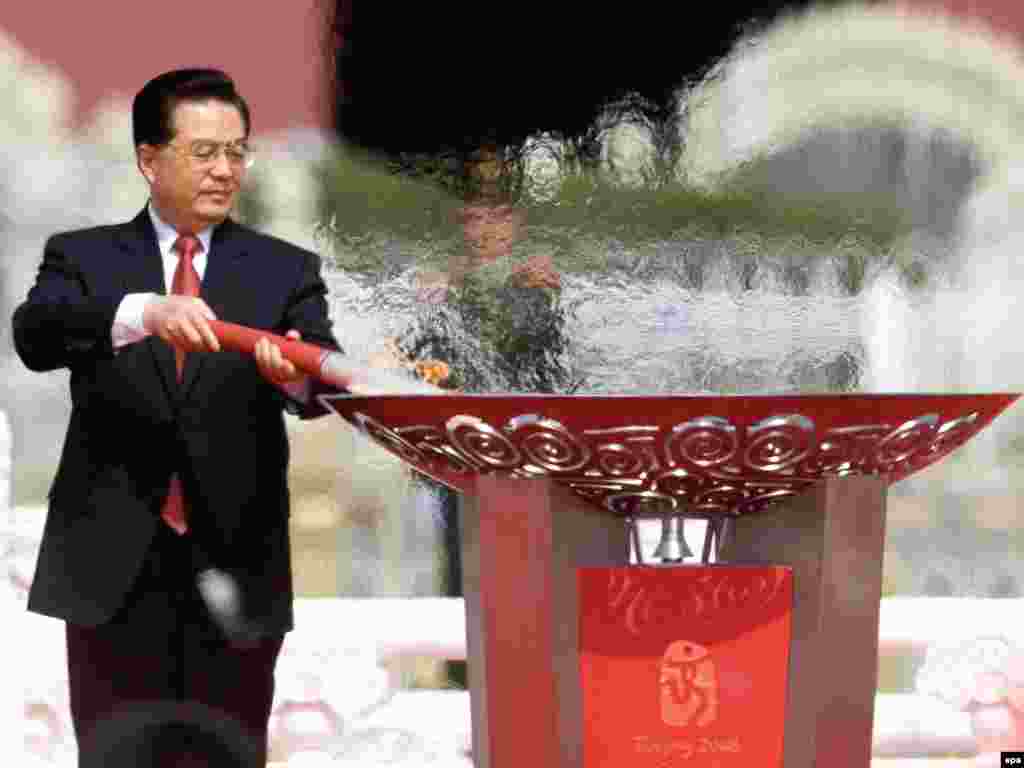 Chinese President Hu Jintao lights the Olympic torch on Tiananmen Square in Beijing on March 31, 2008, ahead of a trip around the world that saw the flame travel 130,000 kilometers.