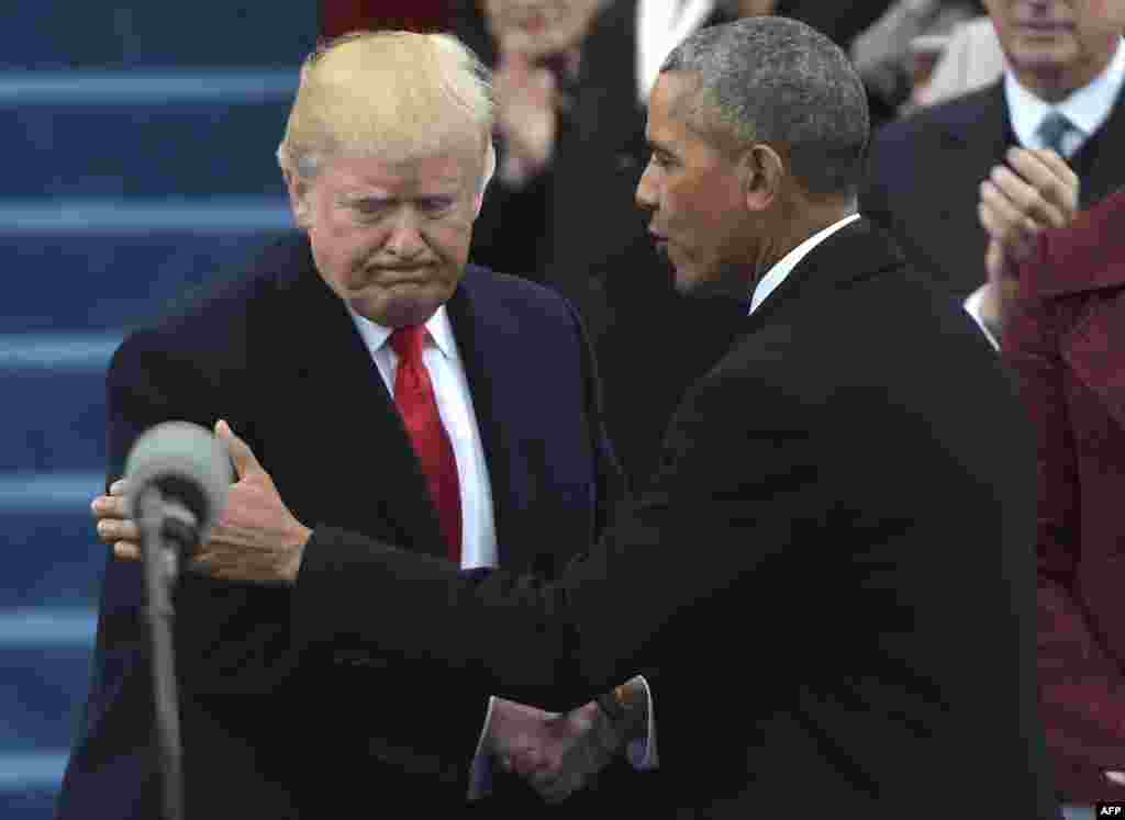 U.S. -- US President Barack Obama (R) greets President-elect Donald Trump as he arrives on the platform at the US Capitol in Washington, DC, on January 20, 2017, before his swearing-in ceremony.