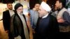 Iranian President Hassan Rohani (right) and Ebrahim Raisi speak just before the second presidential debate on May 5 in Tehran.