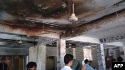 FILE: Residents inspect the site of a suicide bomb attack at a district court in Mardan in September 2016.