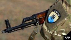 A Ukrainian fighter from the Azov Battalion stands guard at a checkpoint on the outskirts of Mariupol in September.