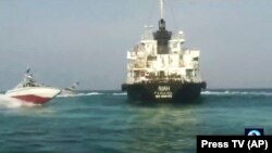 A photo provided by Iranian state TV showing the Panamanian-flagged oil tanker MT Riah surrounded by military vessels from Iran,