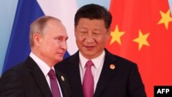 Chinese President Xi Jinping (right) stands next to Russian President Vladimir Putin as he arrives for a group photo during the BRICS Summit in Xiamen on September 4. 