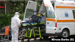 Un pacient cu COVID 19 este preluat de ambulanță