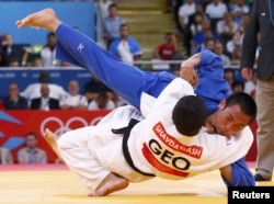 Georgia's Lasha Shavdatuashvili fights with Japan's Masashi Ebinuma (in blue) during their men's 66-kilogram semifinal B judo match on July 29. Shavdatuashvili took home gold.