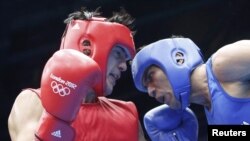 Поединок индийского боксера Маноя Кумара (справа) с соперником из Таджикистана Сердаром Худайбердыевым на Играх в Лондоне. 31 июля 2012 г