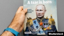 Чоловік тримає журнал The Economist із зображенням на обкладинці президента Росії Володимира Путіна із заголовком «Народився цар». Франція, Страсбург, 28 жовтня 2017 року
