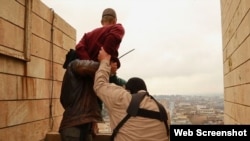 Islamic State militants prepare to throw a man from a high rooftop in Mosul as punishment for being gay.